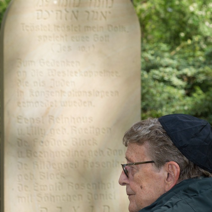 Wolfgang Polak hält vor einem jüdischen Grabstein inne. Er hat den Holocaust durch Flucht überlebt. (vergrößerte Bildansicht wird geöffnet)